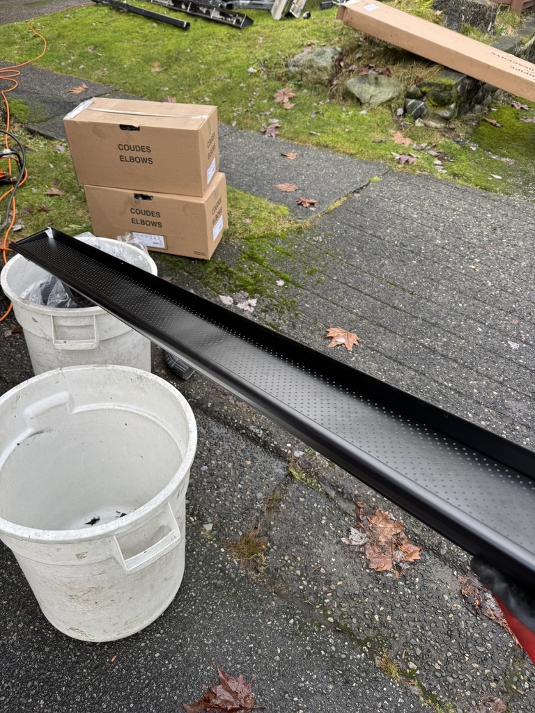 Black gutter guard material staged with installation supplies