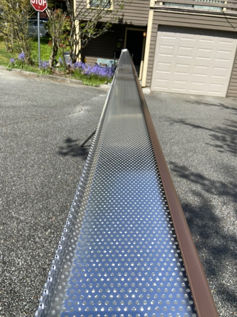 Perforated gutter guard installed in a gutter run
