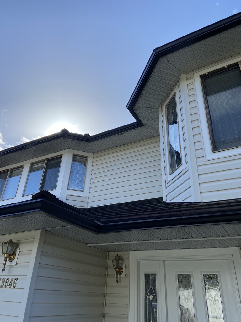 Finished black gutters along a front roofline