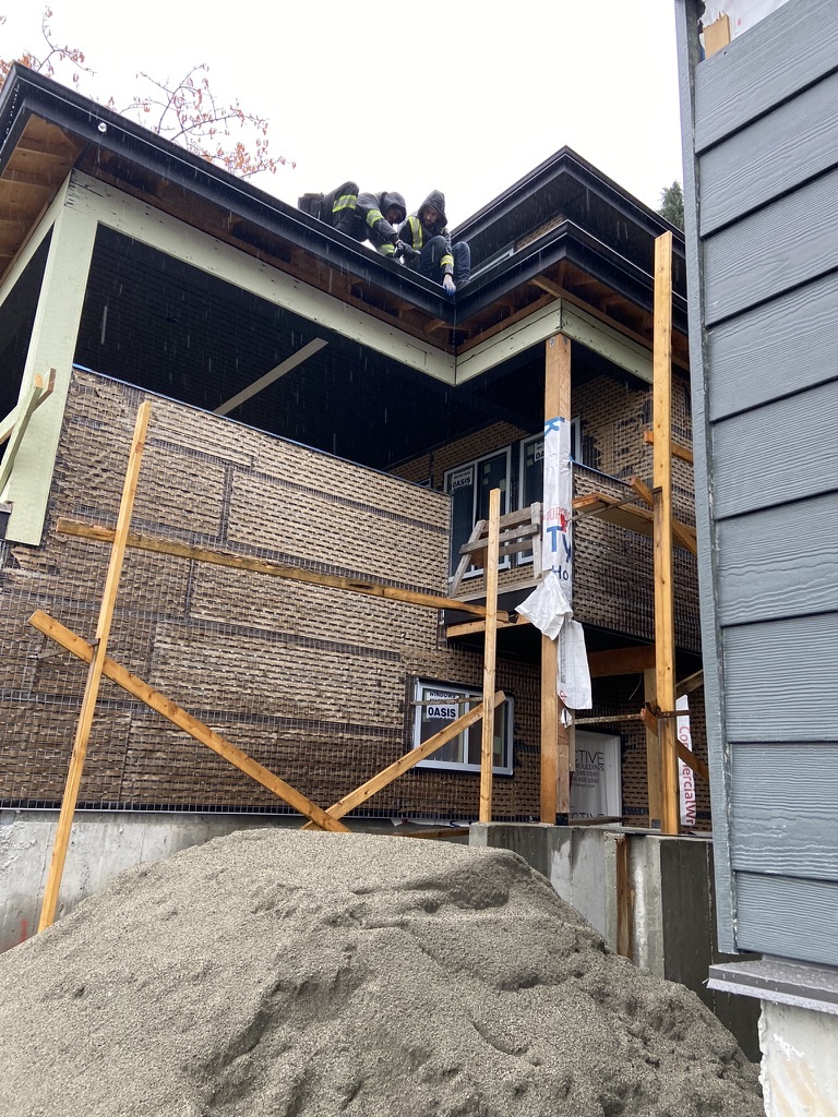 Black gutter installation on a new construction exterior