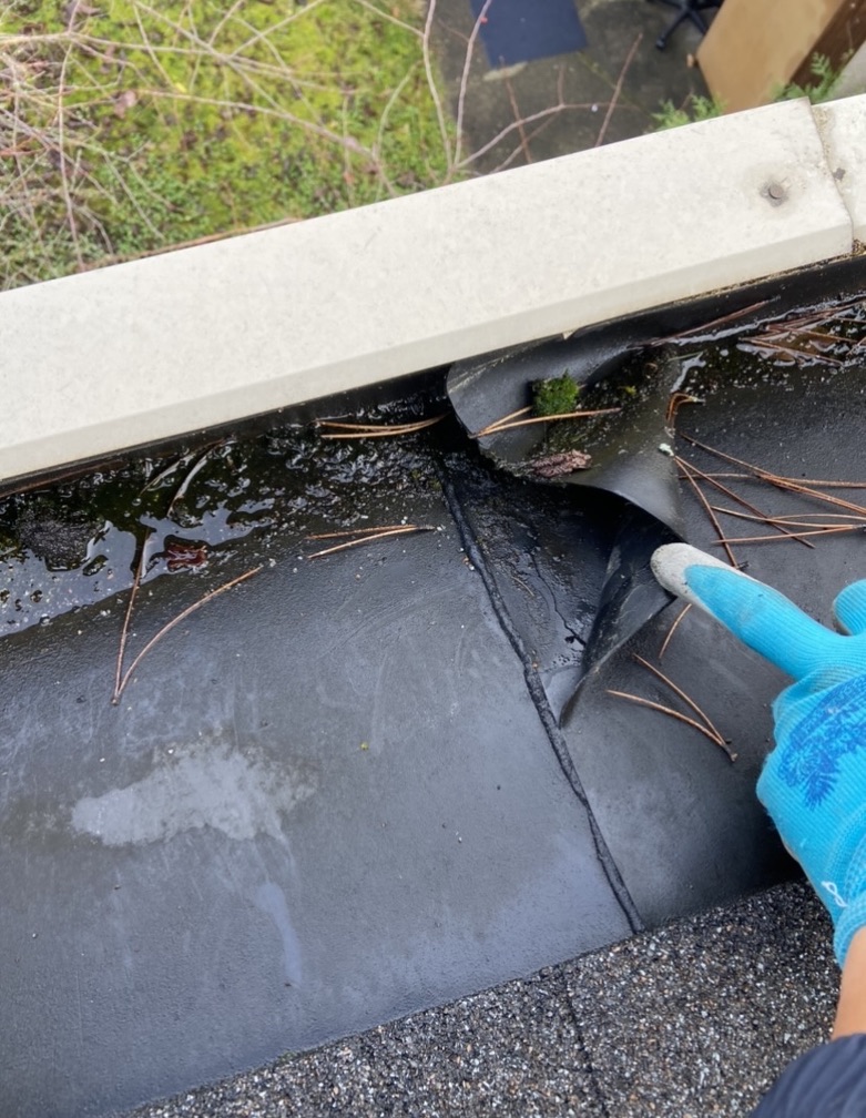 Membrane seam checked during gutter repair