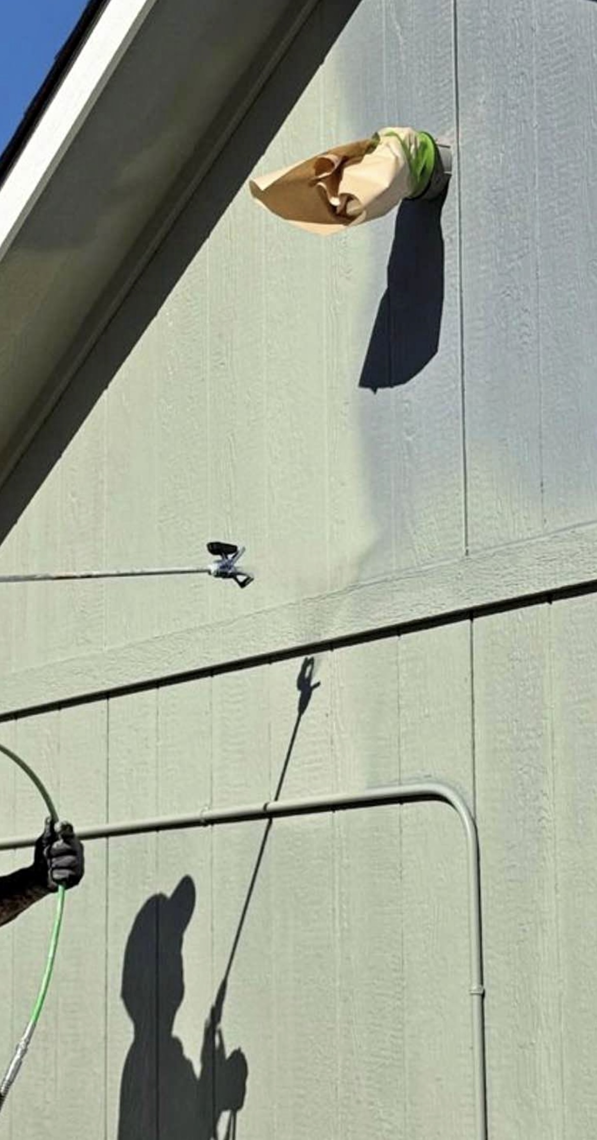 Exterior spray painting detail on wall siding