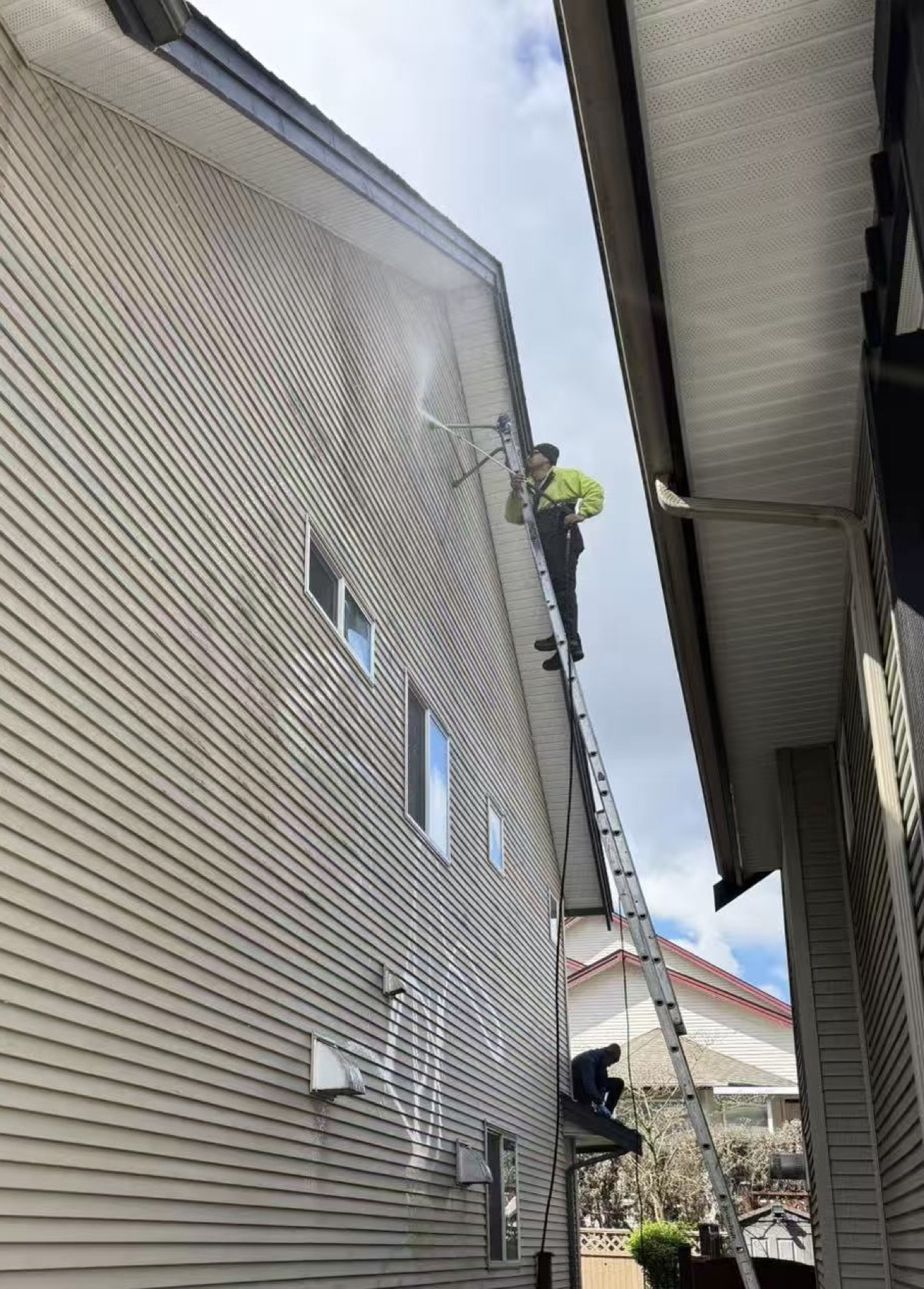 Pressure washing tall residential siding