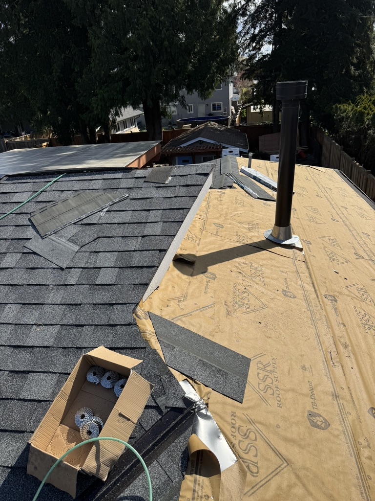 Roof underlayment and pipe flashing installation in progress