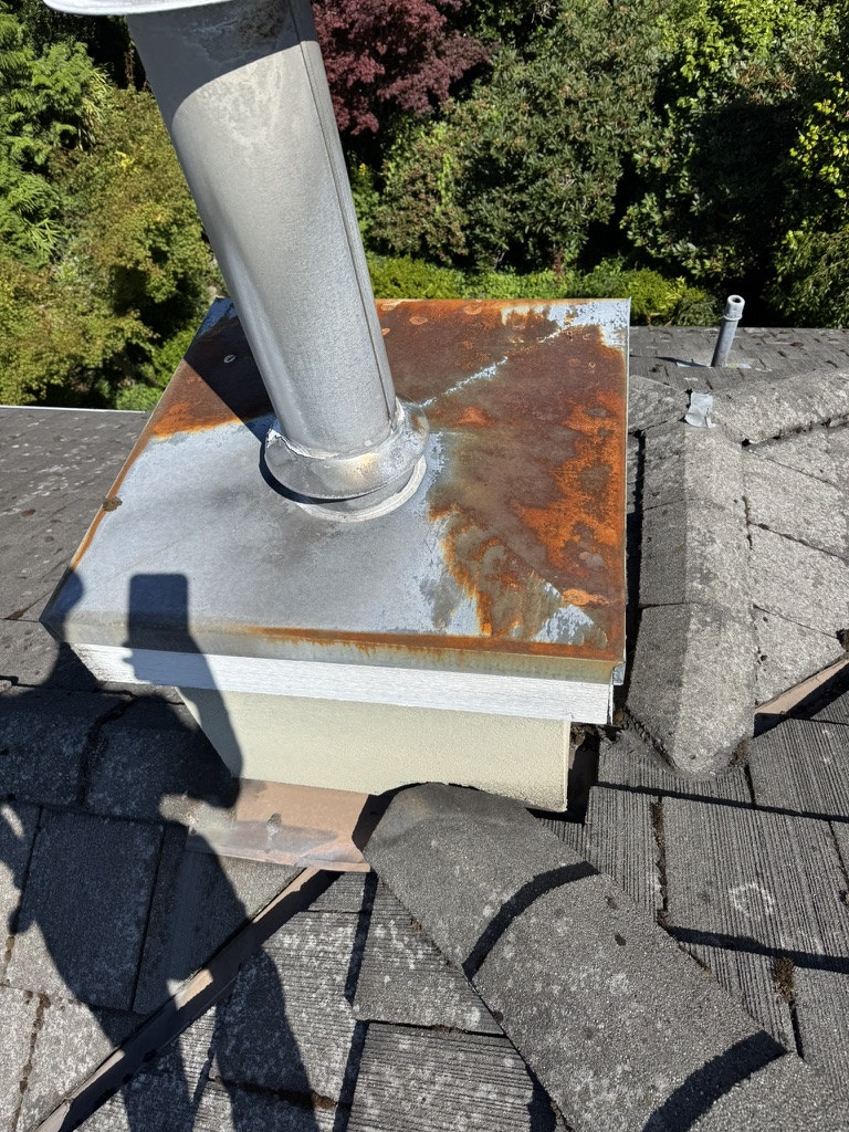 Rusted chimney cap and roof flashing before repair