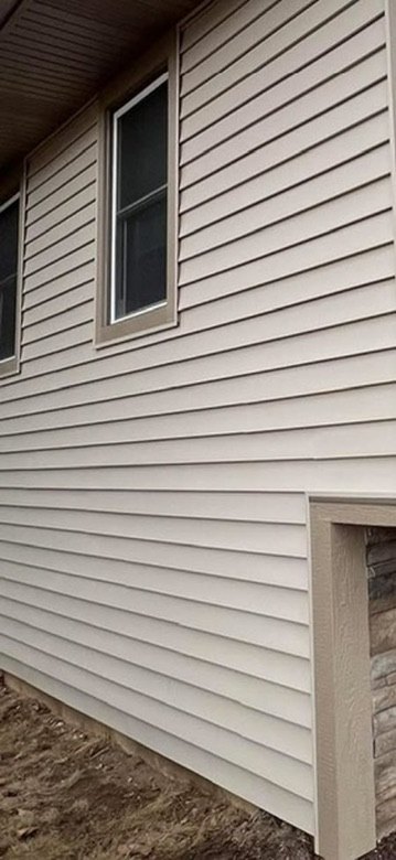 Beige vinyl siding wall with window trim