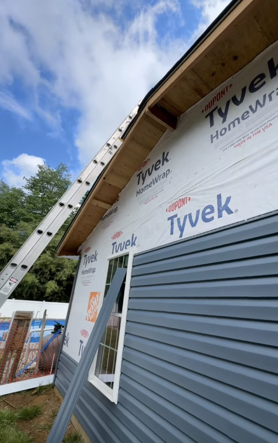 Siding installation in progress over Tyvek housewrap