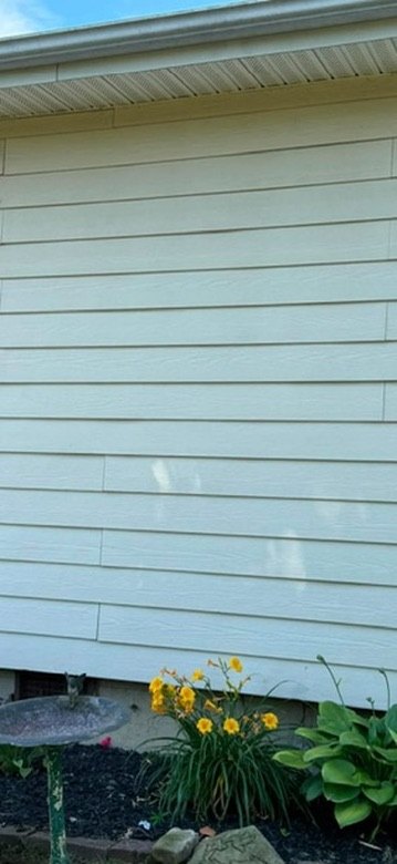 Light vinyl siding wall detail near garden