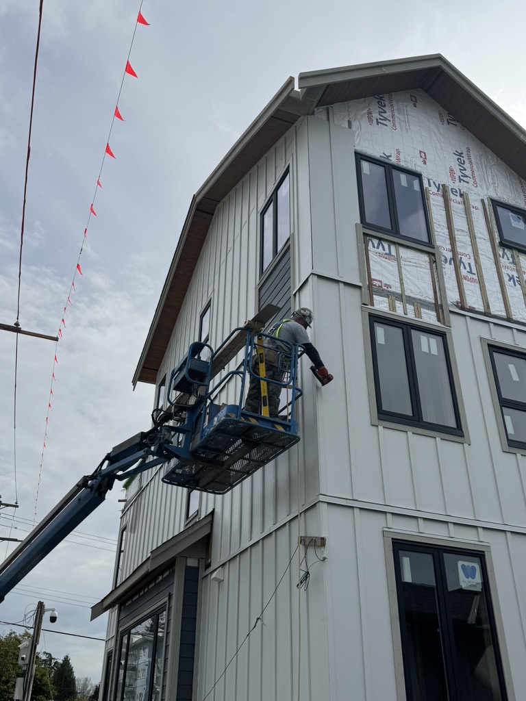 Siding installation in progress from a boom lift