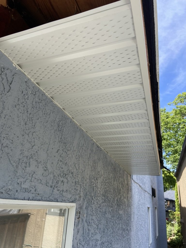 Finished vented soffit installation under a roof edge