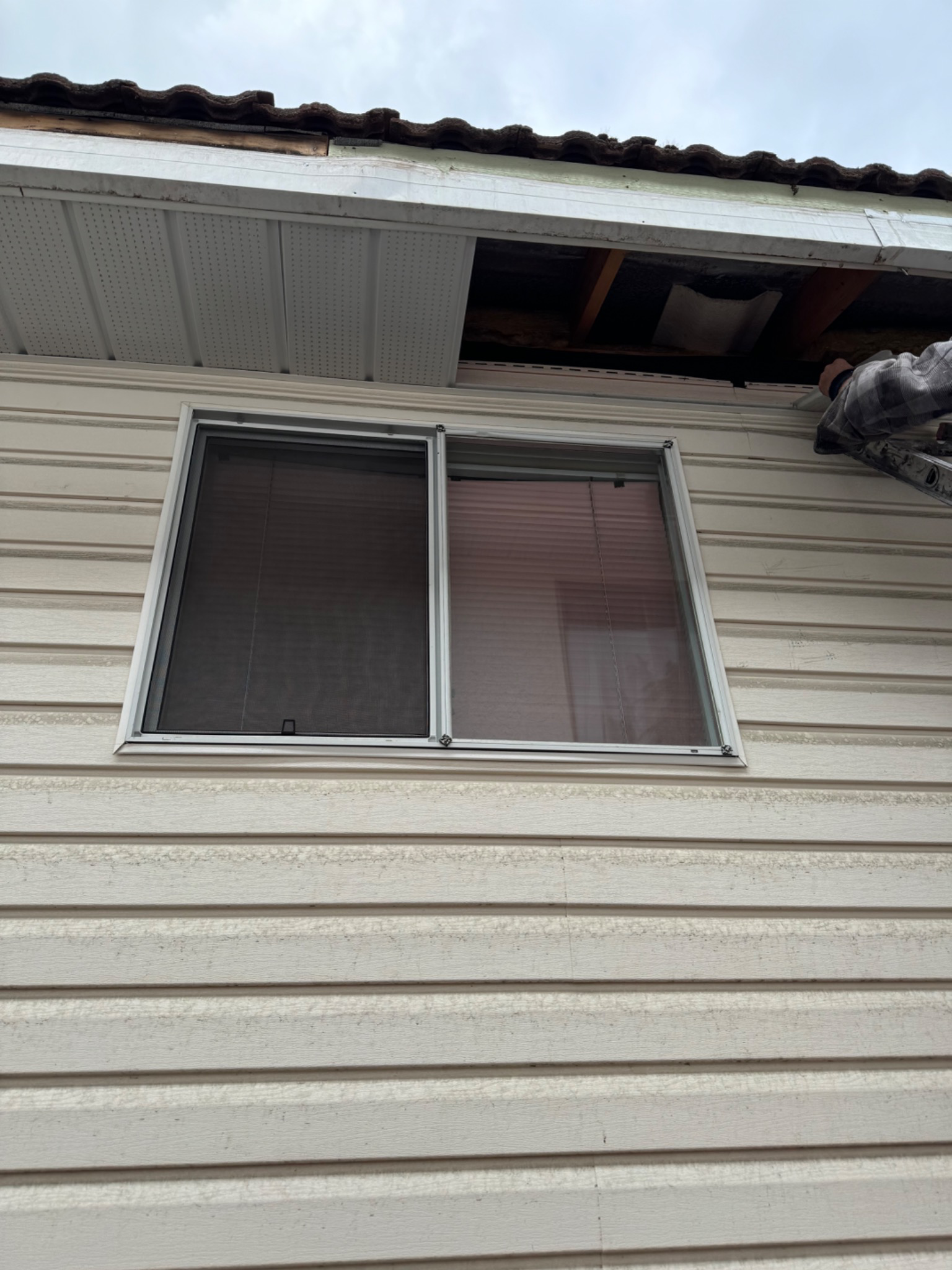 Open soffit repair in progress above a window